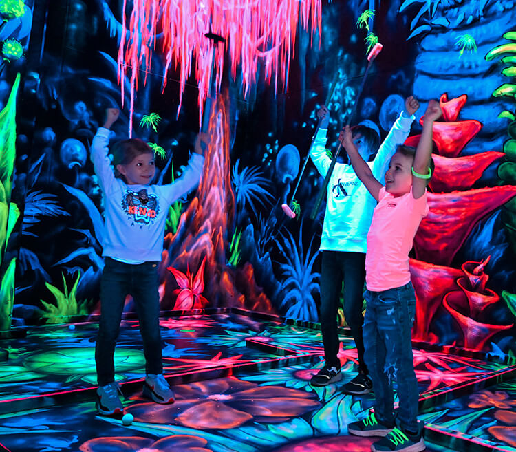 Kinder jubeln während des Gleamgolfspielens